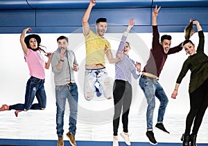 Group of happy friends jumping in underground metro station - Young people having fun together indoor - Happiness and freedom