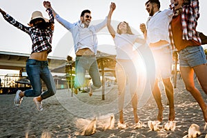 Group of happy friends partying on beach