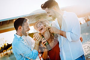 Group of happy friends partying on beach