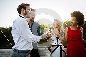 Group of happy friends partying and toasting drinks