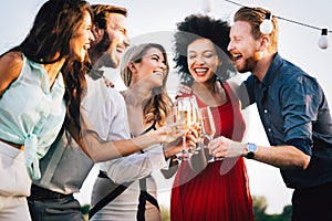 Group of happy friends partying and toasting drinks