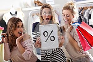 Group of happy friends shopping in store