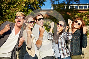 Group of happy friends showing triumph gesture