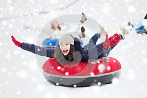 Group of happy friends sliding down on snow tubes