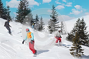 Group of happy friends snowboarders and skiers at ski resort. Winter vacations concept