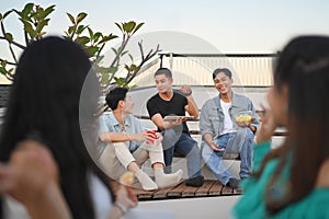 Group of happy friends talking and sharing nice moments together at the rooftop party