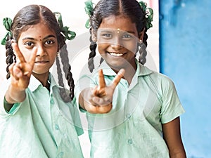 Group of happy funny children friends classmates smiling doing victory peace sign gesture with fingers at the school. School kids