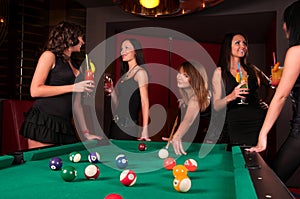 Group of happy girls playing in billiard