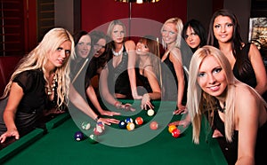 Group of happy girls playing in billiard