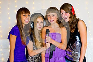 Group of happy girls singing on karaoke