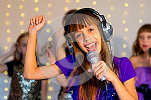 Group of happy girls singing on karaoke