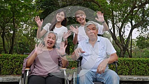 Group of happy grandparents and grandchild talking and laugh together, grandparent sitting on wheelchair. Retirement lifestyle