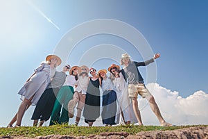 Group of happy joyful young stylish people against blue sky, friendship, community values, travel