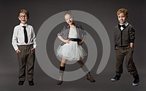 Group of Happy Kids. Fashion Well-dressed Children over Gray Studio Background. Boys and Girl in Smart Casual Clothes Smiling