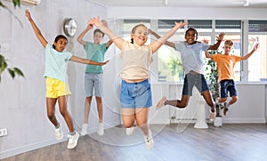 Group of happy kids jumping together in dance studio