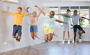 Group of happy kids jumping together in dance studio