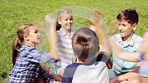 Group of happy kids making high five outdoors