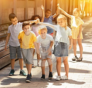 Group of happy kids playing a game called trickle on the street