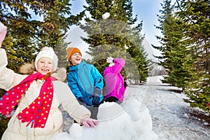 Group of happy kids throw snowballs during fight photo
