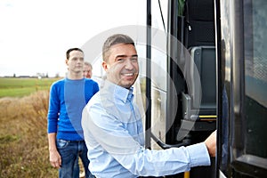 Group of happy male passengers boarding travel bus