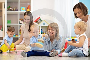 Group of happy moms with their babies in nursery