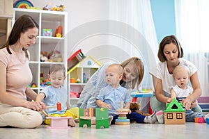 Group of happy moms with their babies in nursery