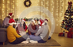 Group of happy multiethnic friends meeting all together at home on Christmas night