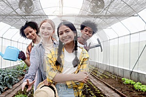 Group of happy Multiethnic teenager friend work in vegetable farm, portrait of smiling young diverse farmer standing together,