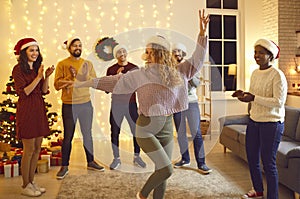 Group of happy multiracial friends dancing and having fun at Christmas party at home