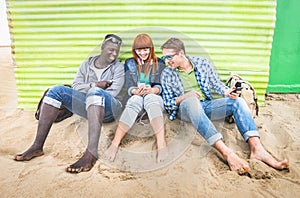 Group of happy multiracial friends having fun together using mobile phone