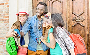 Group of happy multiracial friends taking selfie with mobile phone