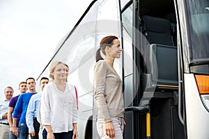 Group of happy passengers boarding travel bus