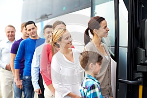 Group of happy passengers boarding travel bus