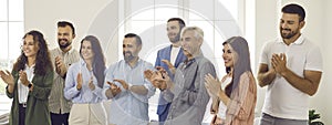 Group of happy people clapping hands to thank speaker for presentation and workshop