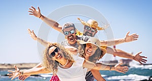 Group of happy people enjoy travel and summer holiday vacation together having fun under the sun - blue ocean water in background