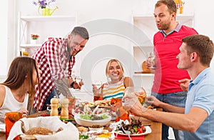 Group of happy people at festive table dinner party