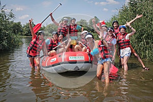 Group of happy people with guide whitewater rafting and rowing on river, extreme and fun sport