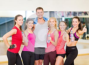 Group of happy people in gym with water bottles
