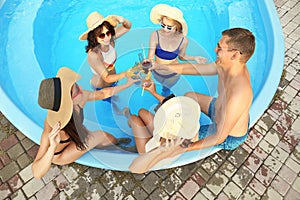 Group of happy people with refreshing drinks enjoying fun pool party