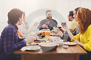 Group of happy people with wine glasses at festive table dinner party