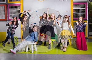 Group of happy preschoolers dancing in playroom