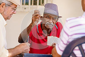 Group Of Happy Senior Friends Playing Cards And Laughing