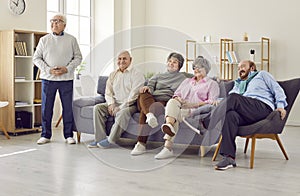 Group of happy senior people watching television at home or in retirement community