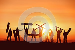 Group of happy silhouettes of skiers and snowboarders