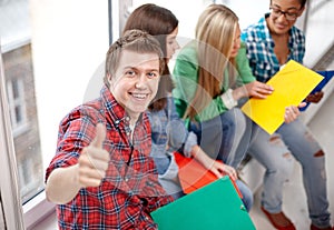 Group of happy students showing thumbs up