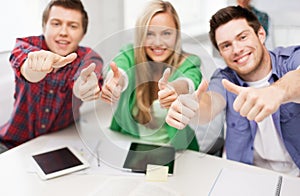 Group of happy students showing thumbs up