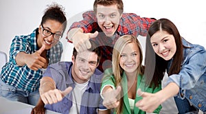 Group of happy students showing thumbs up