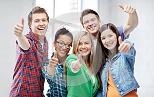 Group of happy students showing thumbs up