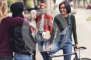group of happy stylish people with vintage bike spending time photo