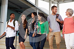 A group of happy teachers walking in a school corridor